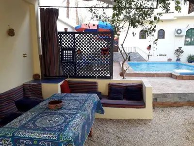a living room with a couch and a swimming pool at Villa Bahri Luxor Apartment in Luxor