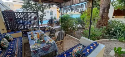 a patio with a table and chairs with food on it at Villa Bahri Luxor Apartment in Luxor