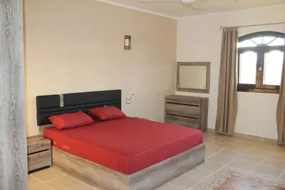 a bedroom with a red bed and a window at The View El Quseir in Quseir