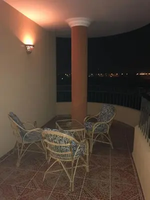 a balcony with chairs and a column at night at The View El Quseir in Quseir