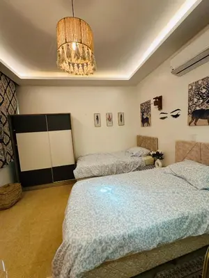 a bedroom with two beds and a chandelier at Alis Villa in Hurghada