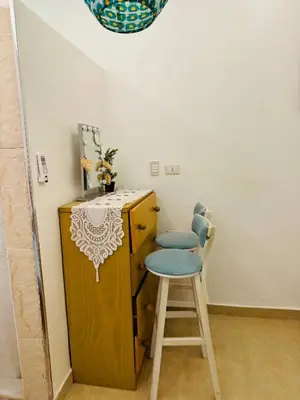 a stool sitting next to a wooden cabinet with a table at Alis Villa in Hurghada