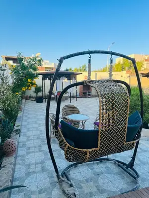 a swing chair on a patio with a table at Alis Villa in Hurghada