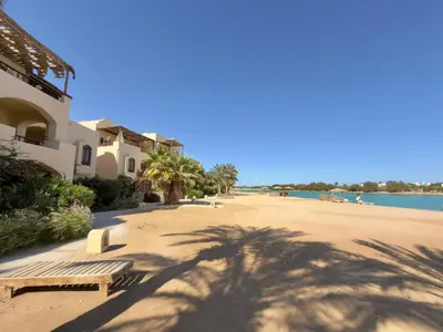 a shadow of a palm tree on a beach at Lagoon view 1-bedroom apartment in West Golf El Gouna in Hurghada