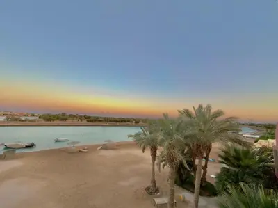 a swimming pool with palm trees in a resort at Lagoon view 1-bedroom apartment in West Golf El Gouna in Hurghada