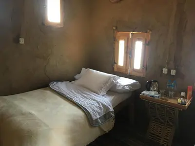 a small bedroom with a bed and a window at Eco Nubia in Aswan
