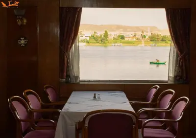 a dining room with a table and chairs and a large window at GTS Nile Cruise Luxor Aswan every monday from Luxor friday from Aswan in Luxor