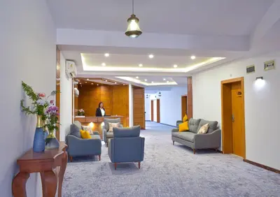 a lobby with couches and chairs and a person in the background at Basma Executive Club in Aswan