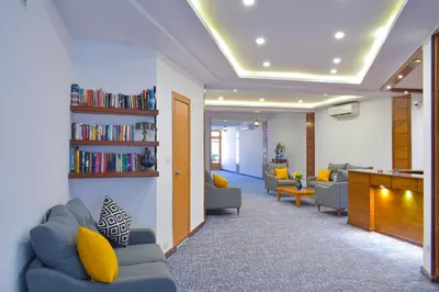 a living room with couches and a book shelf at Basma Executive Club in Aswan