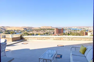 a patio with chairs and a view of a city at Basma Executive Club in Aswan