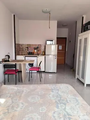 a kitchen with a table and chairs and a refrigerator at Studio 5min from ElGouna and Kite station in Hurghada