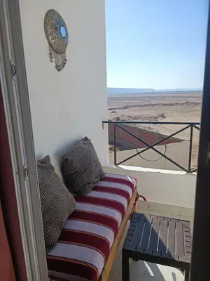 a bench on a balcony with a view of the desert at Studio 5min from ElGouna and Kite station in Hurghada