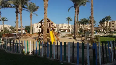 a playground with a slide in a resort with palm trees at Royal Lagoons Resort & Aqua Park Families and Couples Only in Hurghada
