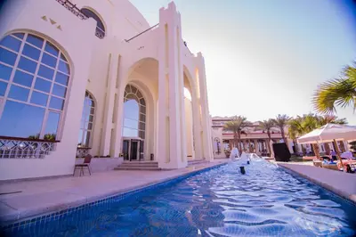 a building with a swimming pool with people walking in it at Royal Lagoons Resort & Aqua Park Families and Couples Only in Hurghada