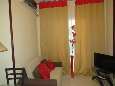 a living room with a couch and a vase with a flower at Apartment Dolce Vita near the sea RedSeaLine in Hurghada