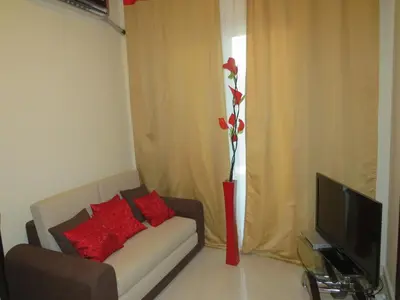 a living room with a couch and a vase with a flower at Apartment Dolce Vita near the sea RedSeaLine in Hurghada
