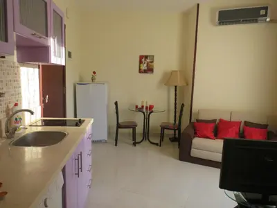 a kitchen with a living room with a couch and a kitchen at Apartment Dolce Vita near the sea RedSeaLine in Hurghada
