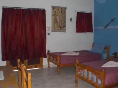 two beds in a room with red curtains at El Fayrouz Hotel in Luxor