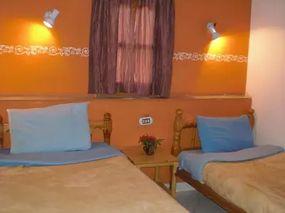 a room with two beds with blue pillows at El Fayrouz Hotel in Luxor