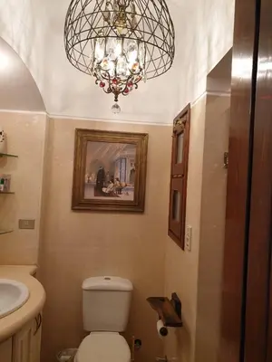 a bathroom with a chandelier and a toilet and a sink at Dar Om Ali ElGouna Sabina y160 2 14 in El Gouna