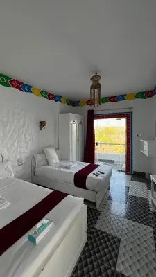 a hotel room with two beds and a window at Onaty Ka Guest House in Aswan
