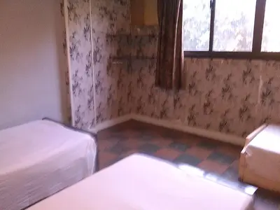 a small room with two beds and a window at Pharaohs Hotel in Luxor