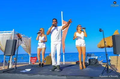 a group of people on the beach singing into a microphone at Titanic Royal-Families and Couples only in Hurghada