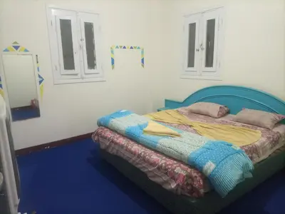a bedroom with a bed with a blue head board at Hana hostel not for Egyptian in Hurghada