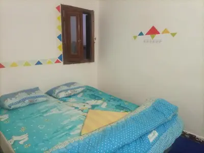 a bedroom with a bed with blue sheets at Hana hostel not for Egyptian in Hurghada
