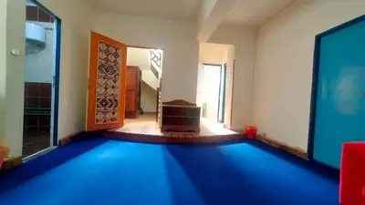 a room with a blue carpet in front of a door at Hana hostel not for Egyptian in Hurghada