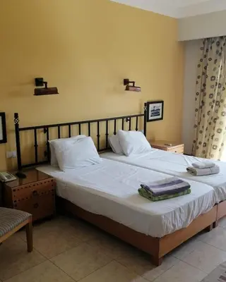 a bedroom with a large bed with white sheets and pillows at EL Gouna Abu tig Studio- Economy stay in Hurghada