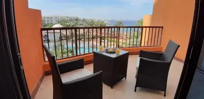 a balcony with chairs and a table with a view at Alia Beach Residence in Hurghada