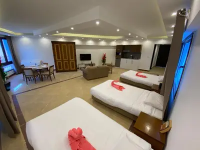 a hotel room with two beds and a living room at Alia Beach Residence in Hurghada