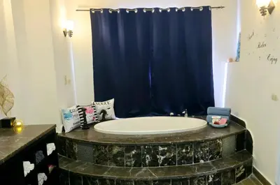a bathroom with a tub with a blue shower curtain at Luxury Royal Blue Family Villa 8pers private pool in Hurghada