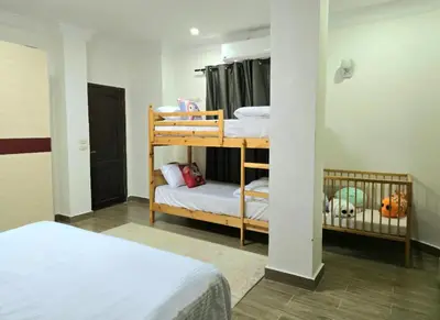 a bedroom with two bunk beds and a crib at Luxury Royal Blue Family Villa 8pers private pool in Hurghada