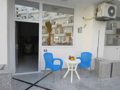 a table and blue chairs in a room at Apartment Bella Donna near the sea RedSeaLine. in Hurghada