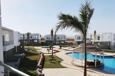 a view of a resort with a pool and palm trees at Sky Star Villa 25 in Hurghada