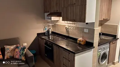 a kitchen with a sink and a stove top oven at Stylish Pool view studio in Al Dau Heights in Hurghada
