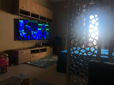 a living room with a flat screen tv on a wall at Stylish Pool view studio in Al Dau Heights in Hurghada