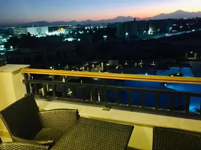 a balcony with two chairs and a view of a city at Stylish Pool view studio in Al Dau Heights in Hurghada