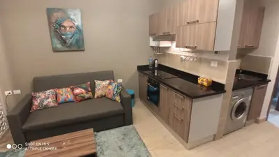 a small living room with a couch and a kitchen at Stylish Pool view studio in Al Dau Heights in Hurghada