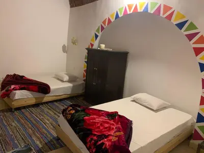 a room with two beds and a rainbow wall at Nubian Farm Aswan in Aswan