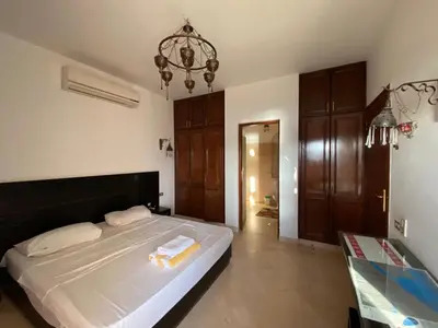 a bedroom with a large bed and a chandelier at Sabina El Gouna - Pool and Lagoon Ap-2 in Hurghada