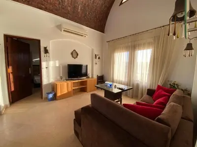 a living room with a couch and a tv at Sabina El Gouna - Pool and Lagoon Ap-2 in Hurghada