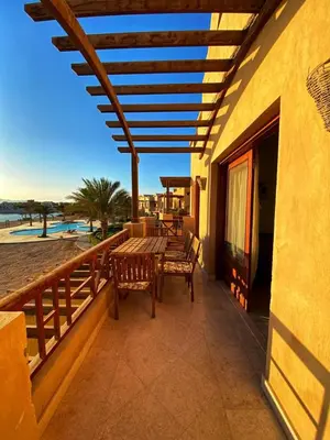 a patio with a table and benches on a balcony at Sabina El Gouna - Pool and Lagoon Ap-2 in Hurghada