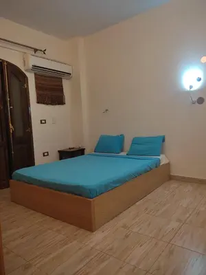a bedroom with a large bed with blue pillows at Habibi Nubian Guest House-Nubian Hospitality in Aswan