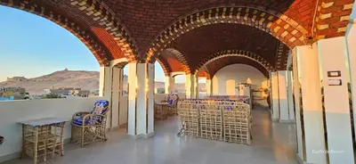 a room with chairs and tables in a building at Habibi Nubian Guest House-Nubian Hospitality in Aswan