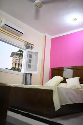 a bedroom with a bed with a pink wall at Kosh royal house in Aswan