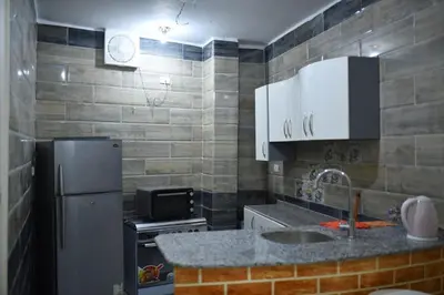 a small kitchen with a sink and a refrigerator at Kosh royal house in Aswan