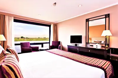 a hotel room with a bed and a large window at Jaz Crown Prince Nile Cruise - Every Monday from Luxor for 07 & 04 Nights - Every Friday From Aswan for 03 Nights in Luxor